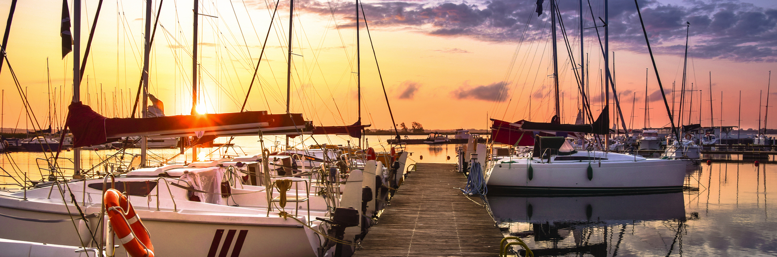 Boote, die bei Sonnenaufgang im Yachthafen am Niegocin-See anlegen, nahe Wilkasy, Masuren, Polen.